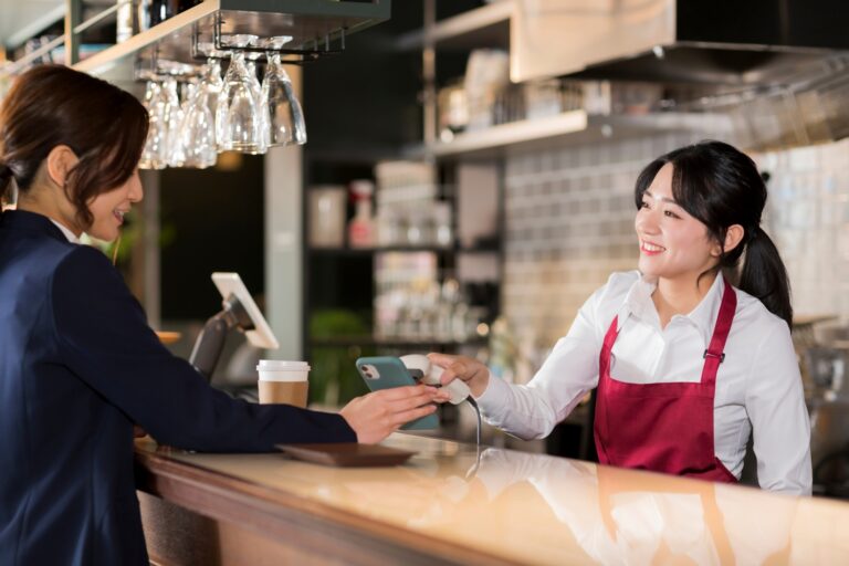 カフェでキャッシュレス決済をする女性