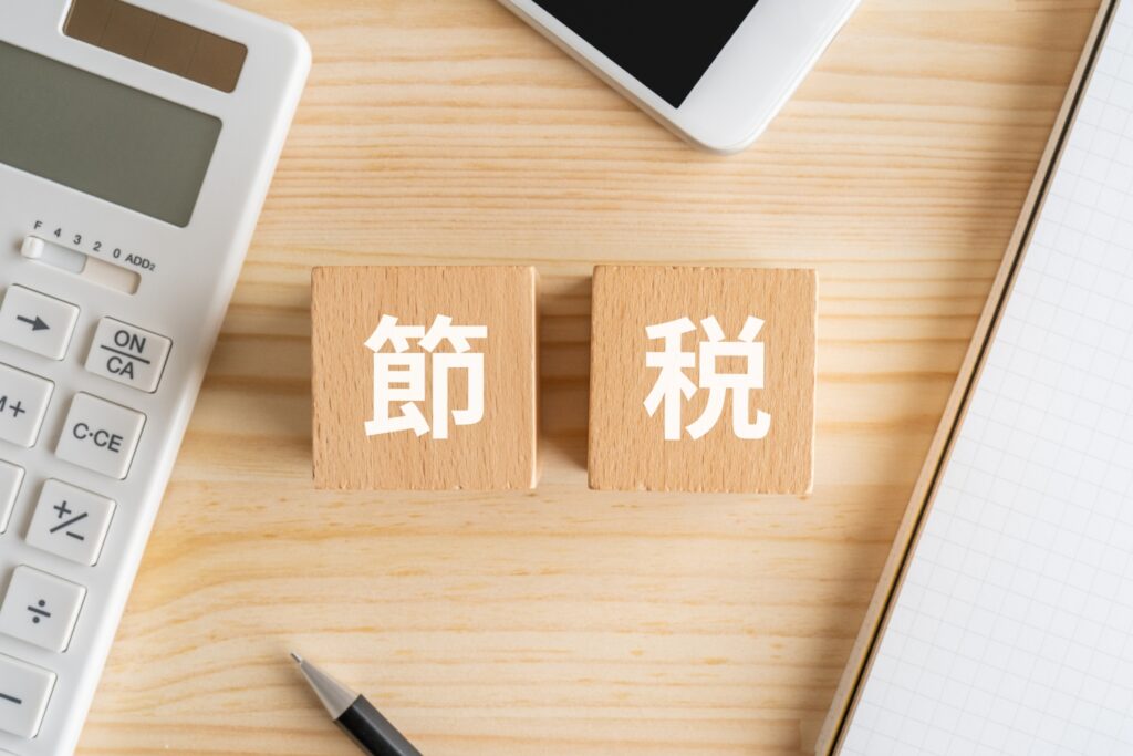 節税と書かれたブロック、電卓、スマホ、ノート