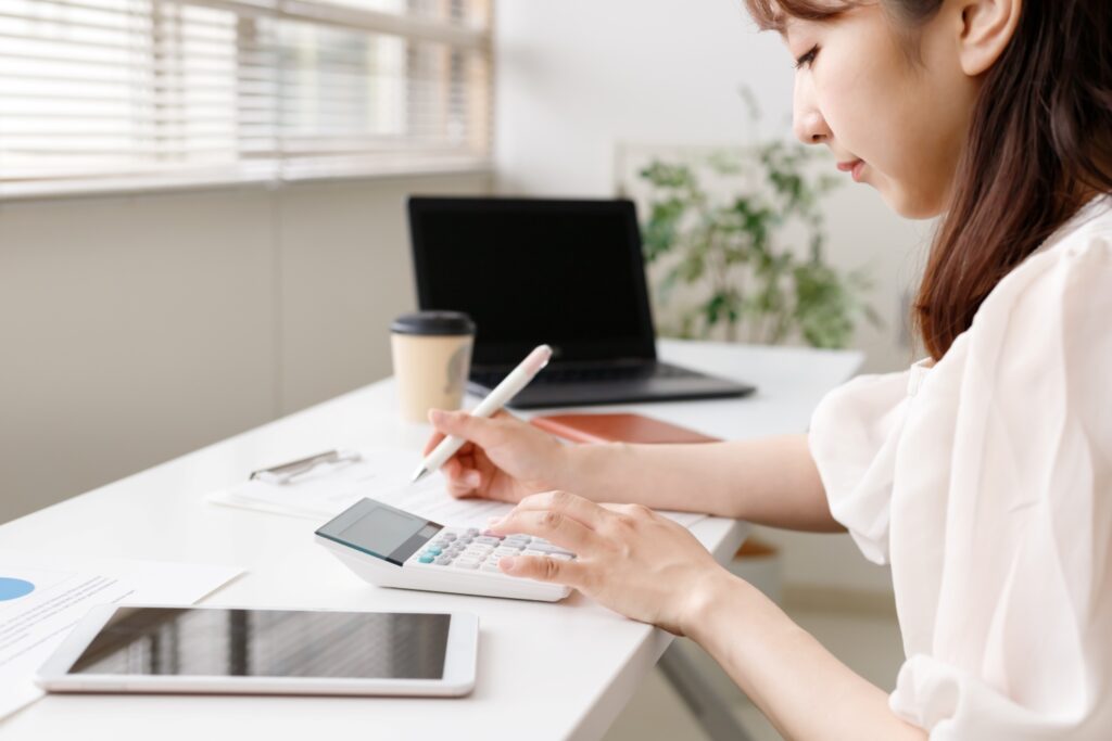 オフィスで働く女性。計算、データ分析、マーケティングイメージ。