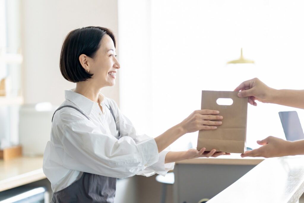 カフェで笑顔で接客をする女性スタッフ
