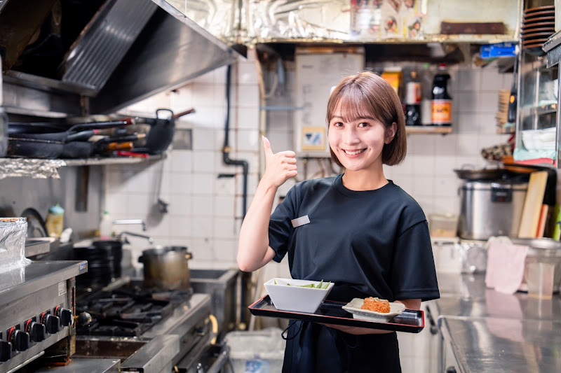 飲食店の厨房で働く若い女性のスタッフ