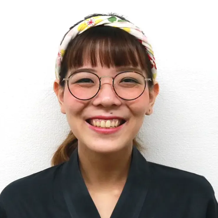 絶好調てっぺんの泉 萌子氏が、花柄のヘアバンドと丸眼鏡で笑っている